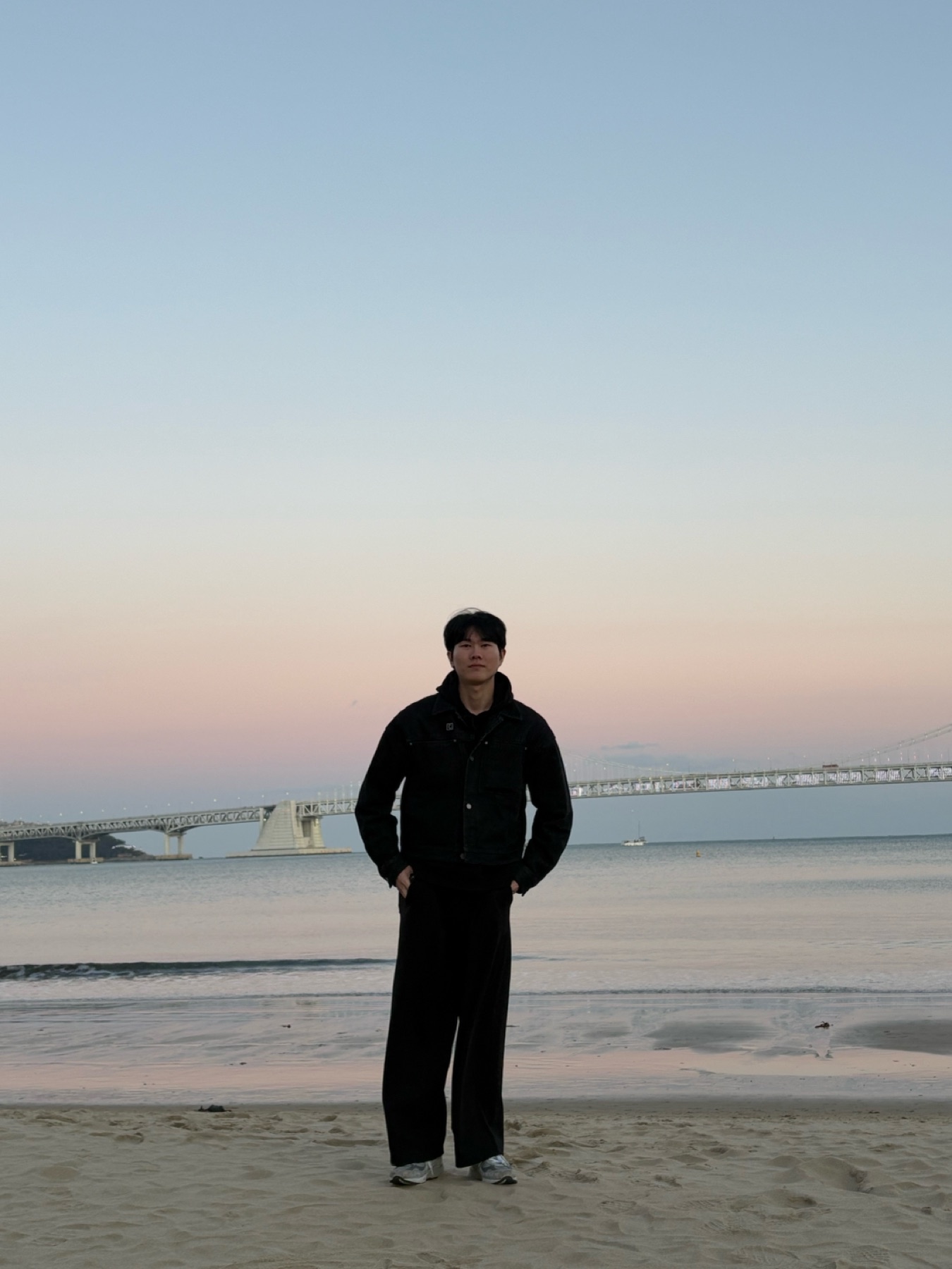 해질녘 광안대교 앞 바닷가에 선 주병주